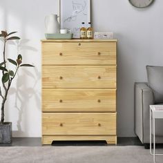 a wooden dresser sitting in a living room next to a chair and potted plant