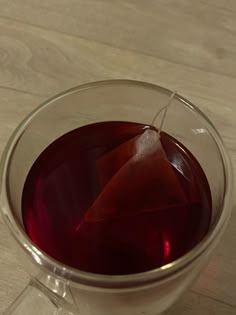 a glass cup filled with liquid on top of a wooden table