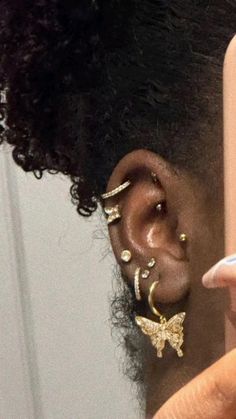 a close up of a person with ear piercings and an electronic device in their hand