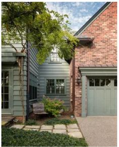 a brick house with two garages and a stone walkway leading to the front door