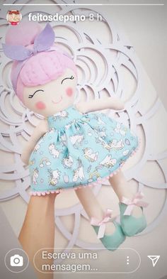 an image of a doll with pink hair on her head and blue dress in front of a white background