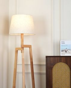 a wooden floor lamp next to a radio