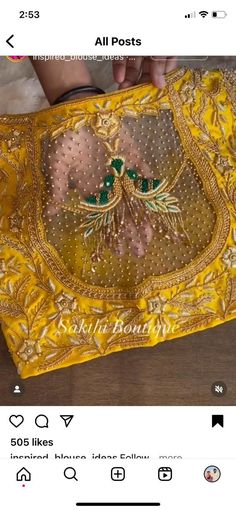 an embroidered yellow cloth with green and gold designs on it, sitting on a wooden table