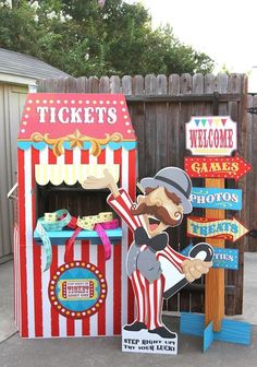 a carnival booth with signs for tickets and games