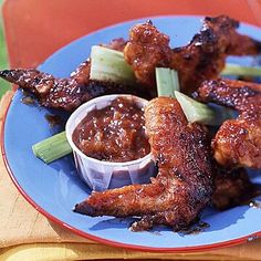 chicken wings with sauce and celery on a blue plate