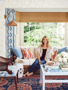 a woman sitting on a couch in front of a window