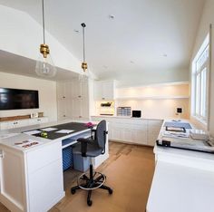 an office with white cabinets and black desk