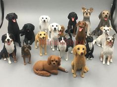 a group of dogs sitting next to each other on a gray surface with their tongue out