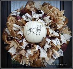 a white pumpkin sitting on top of a burlock wreath with words that say grateful