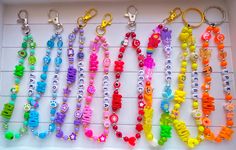 many different colored beads are arranged in a row on a white board with letters and numbers attached to each bead