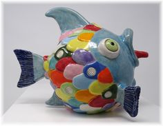 a colorful ceramic fish sitting on top of a table