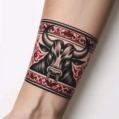 a tattoo on the arm of a person with a bull head and red border around it