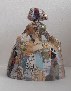 a small bag made out of old newspaper and other things is shown on a white surface