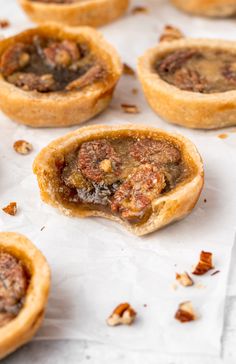 several small pastries sitting on top of a piece of paper with nuts in them