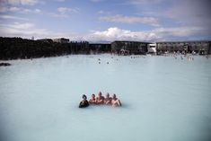 several people are sitting in the middle of a blue lagoon