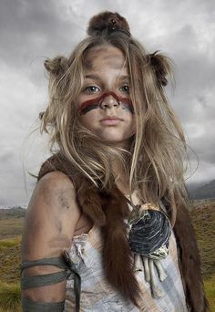 a woman with long hair and makeup is standing in the middle of an open field