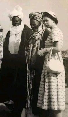 three women standing next to each other in dresses and head scarves on their heads