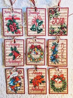 christmas cards hanging on a wall with ribbons and bows around them, all decorated in different designs