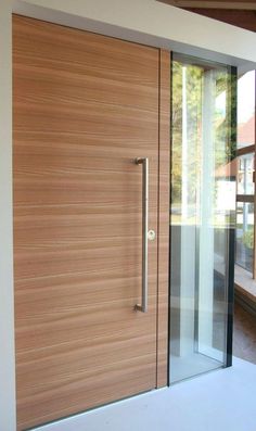 a modern wooden door with glass panels on the outside