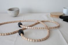 three wooden beads on a table next to a cup