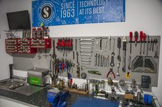 there are many tools hanging on the wall in this garage workbench, including wrenches, pliers and screwdrivers