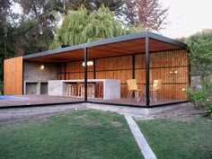 a modern house with a pool in the back yard and covered patio area next to it