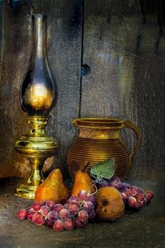 a gold vase and some fruit on a table