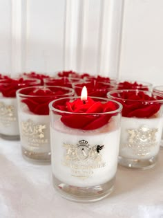 there are many small candles with red roses in them