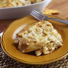 a yellow plate topped with food next to a bowl of macaroni and cheese