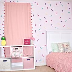 a bedroom decorated in pink and white with sprinkles on the wall