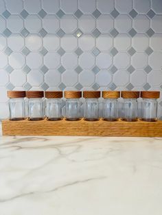 Made from high-quality red oak wood, this coffee bean storage is built to last and will be a stylish addition to your kitchen. It features multiple jars to store and organize all of your favorite coffee beans and the compact design allows it to fit easily on your countertop or in a pantry. The sleek and modern design of the coffee bean storage will complement any kitchen decor, and the natural wood finish gives it a warm and welcoming touch.  Base dimensions: 16.5 x 2 x 1.5 inches. (L x W x H) Coffee Bean Storage, Coffee Jar, Coffee Holder, Red Oak Wood, Coffee Box, Coffee Container, Coffee Jars, Coffee Storage, Coffee Canister