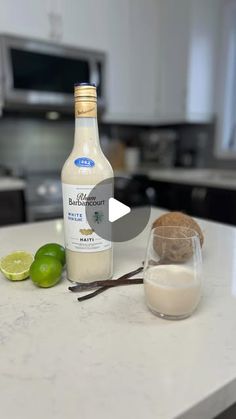 a bottle of white wine sitting on top of a counter next to a glass filled with liquid