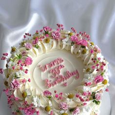 a birthday cake decorated with flowers and the words happy birthday written in pink frosting