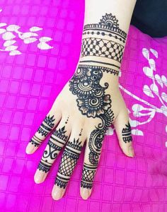 a woman's hand with henna tattoos on it