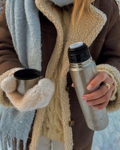 a woman holding a coffee cup in her hand