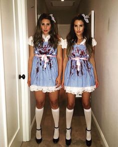 two women dressed in costumes standing next to each other on a hallway way with the door open