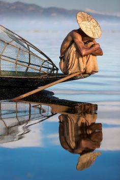 a man sitting on top of a boat with a net over it's head