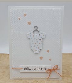 a card with a baby's bib on the front and an orange ribbon around it