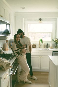 a man and woman standing in a kitchen next to each other