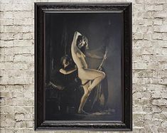 an old photo of a naked woman in front of a brick wall with a black frame