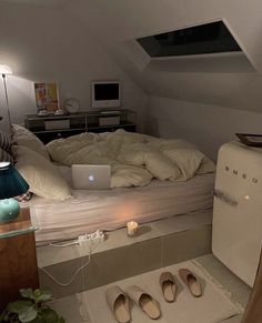 there is a laptop on the bed in this attic dormer, which has been converted into a bedroom