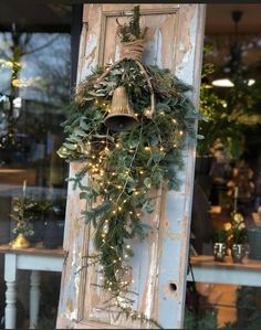 an old door is decorated with greenery and lights