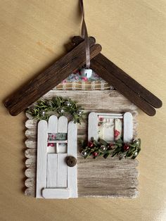 a wooden house ornament hanging on a wall