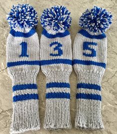 three blue and white knitted mittens with numbers on them