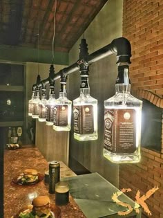 four bottles are hanging from the ceiling above a counter