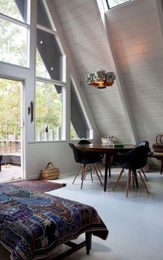 a bed sitting in a bedroom next to a window filled with lots of windows and furniture