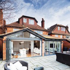 the back of a house with an enclosed patio and outdoor living area in front of it