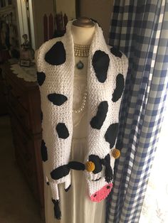 a cow scarf is hanging on a mannequin