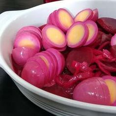 a bowl filled with red onions on top of a table