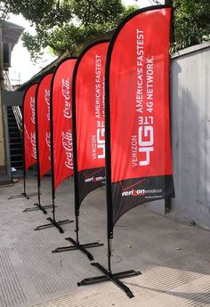 red and black banners are lined up on the sidewalk